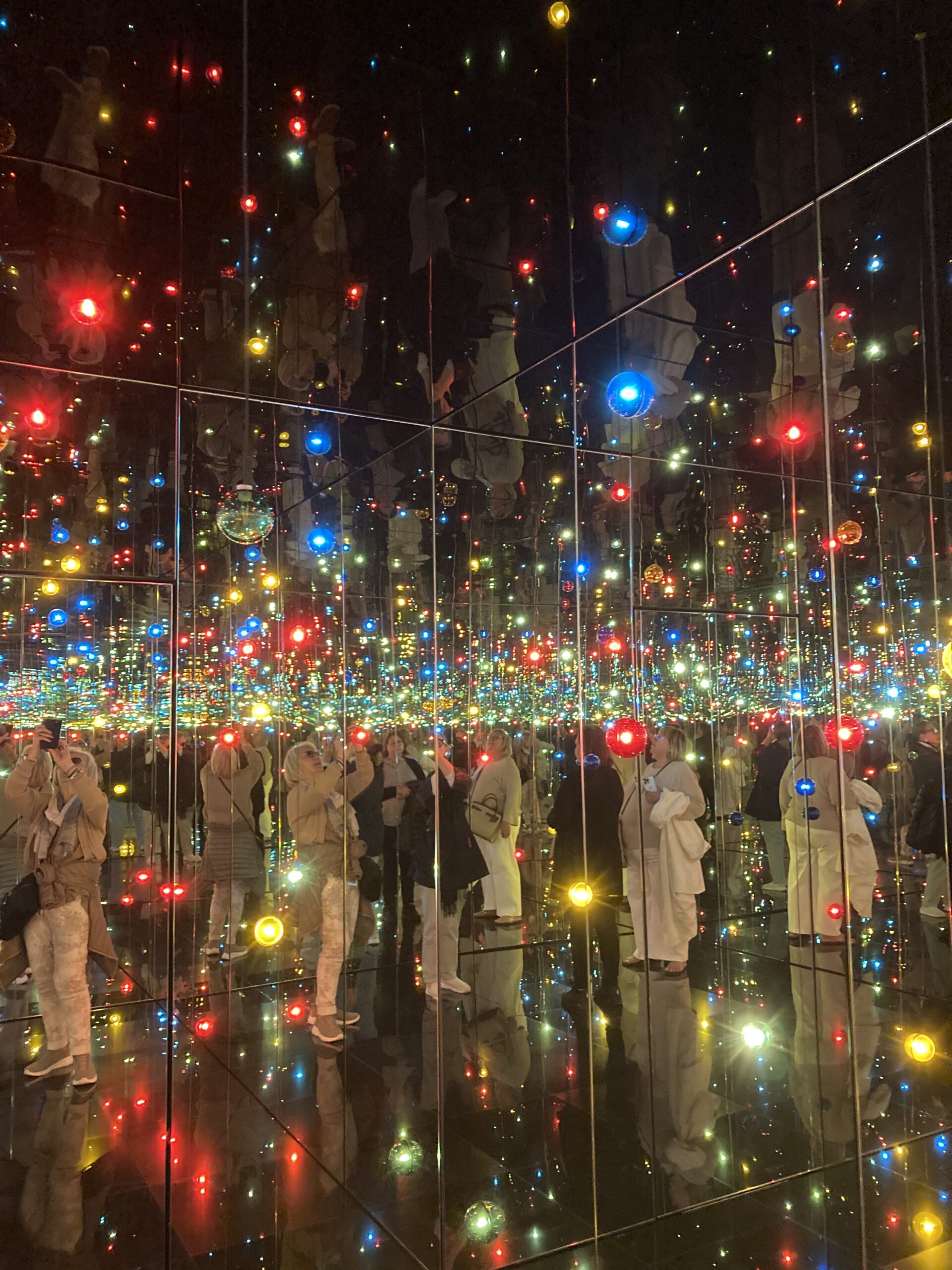 Mirrored room with countless multicolored LED lights reflecting endlessly, creating the illusion of infinite space by Yayoi Kusama in the Guggenheim, Bilbao.