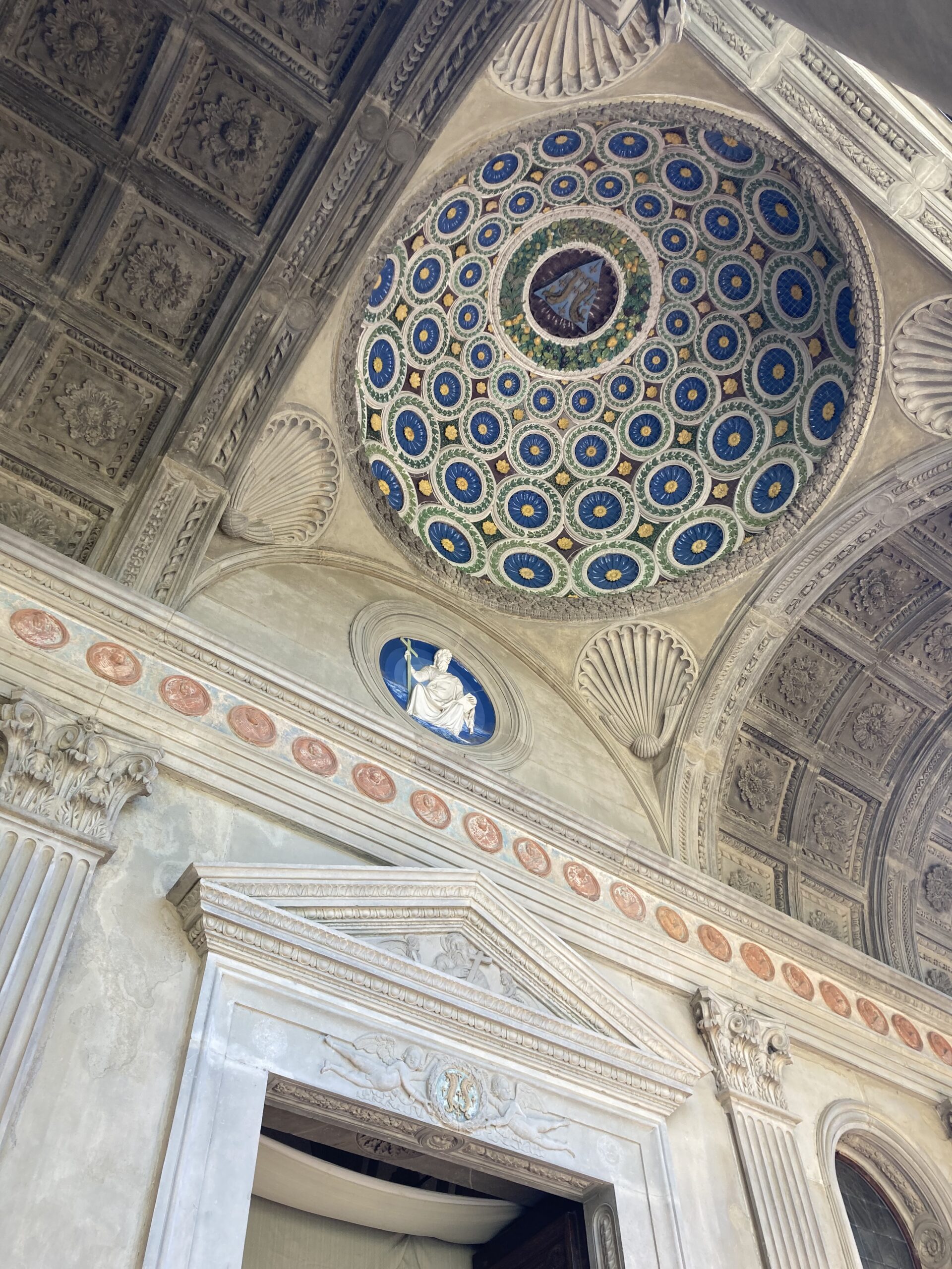 Glazed terracotta portico dome by Luca della Robbia in the Cappella dei Pazzi, Florence, showing blue and white decoration with Pazzi coat of arms tondo.