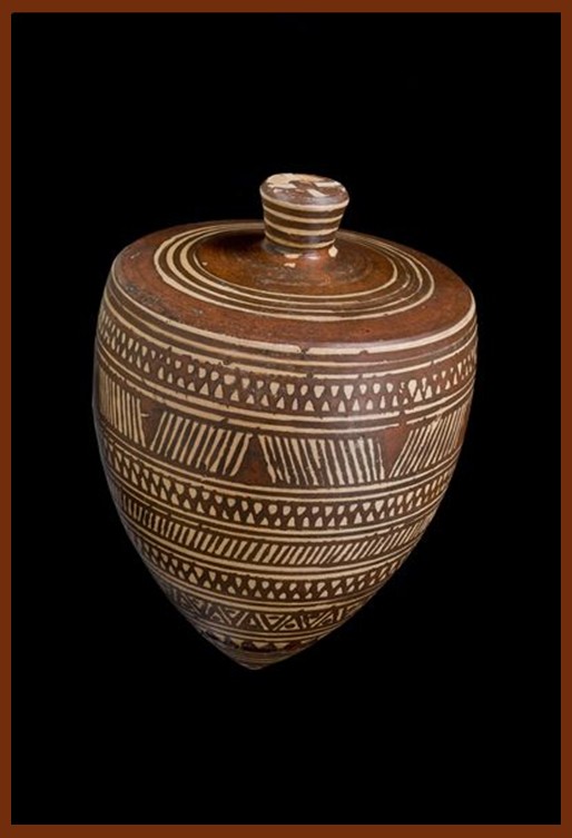 Ancient Greek clay spinning top from the Geometric Period (800–760 BC), decorated with painted geometric patterns and displayed upright at the Acropolis Museum, Athens.